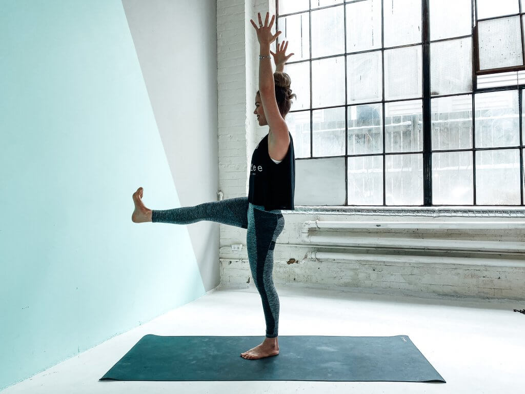 Woman practicing One-Legged Mountain Pose.
