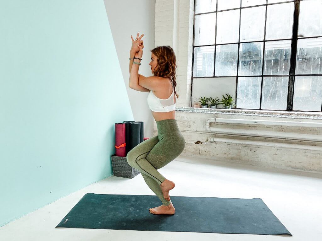 Woman balancing in a tight Eagle Pose wrap.