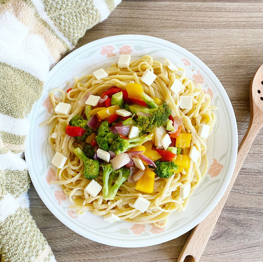 A creamy bowl of vegan fettuccine alfredo with fresh basil.
